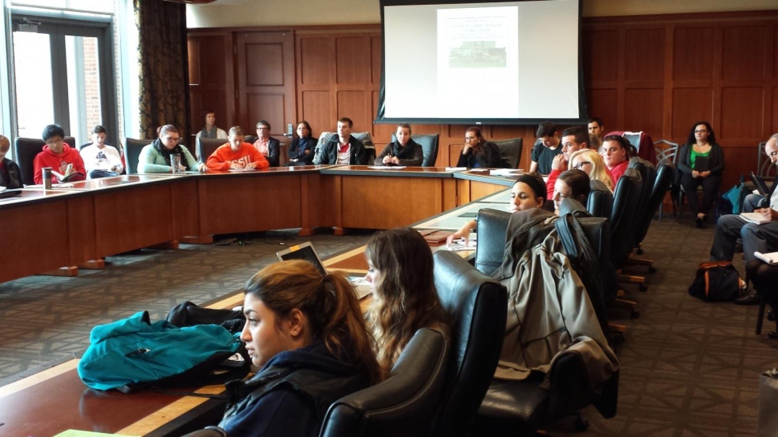 A photograph of a large group of people in a boardroom.