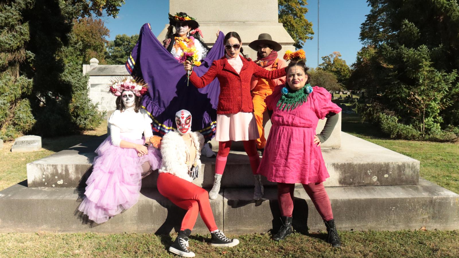 Dancing performing group in front of gravestone